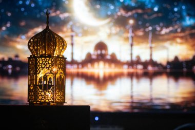 Gece yanan mum ve arka planda cami ile süslenmiş Arapça bir fener. Müslüman kutsal ayı Ramazan Kareem için kutlama kartı.