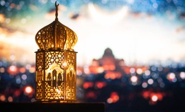 Gece yanan mum ve arka planda cami ile süslenmiş Arapça bir fener. Müslüman kutsal ayı Ramazan Kareem için kutlama kartı.