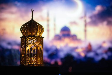 Gece yanan mum ve arka planda cami ile süslenmiş Arapça bir fener. Müslüman kutsal ayı Ramazan Kareem için kutlama kartı.