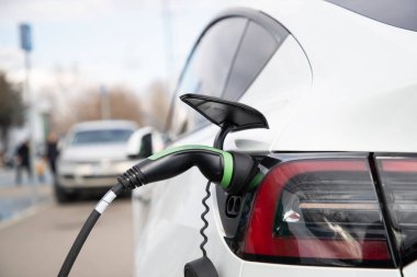 Elektrikli araba park yerinde şarj oluyor. 
