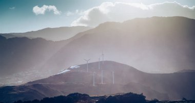Dramatik bir manzaradaki yel değirmenleri yeşil enerji