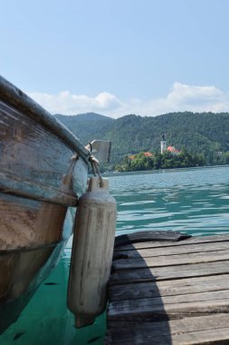 Arka planda Bled Island 'daki Varsayım Kilisesi' ni gösteren ahşap bir teknenin yakın çekimi..