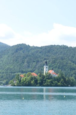 Bled Island 'daki Varsayım Kilisesi yemyeşil orman ve sakin göl sularıyla çevrili..