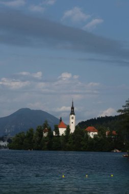 Bled Island 'daki Hüküm Kilisesi' nin dramatik bulutları ve mavi sularıyla ikonik manzarası..