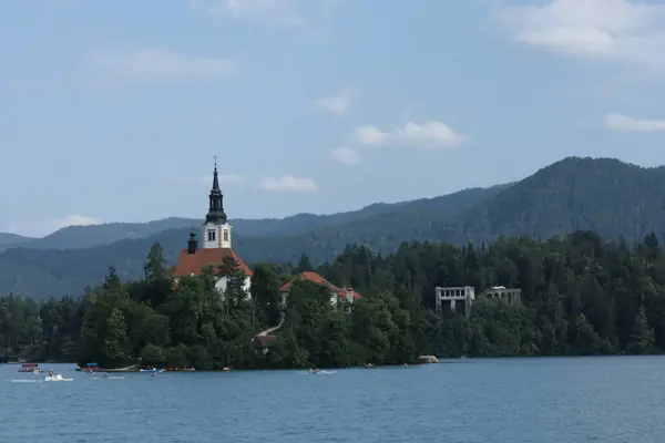 Bled Island 'daki kilisenin geniş bir manzarası ve göldeki tekneleri var..