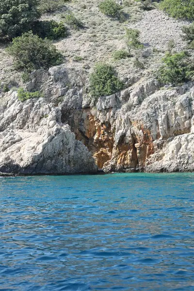 Hırvatistan 'daki turkuaz Adriyatik Denizi üzerinde altın renkli uçurum oluşumları.