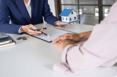 Emlakçı ve müşteri sözleşmesine satın house, sigorta ya da kredi emlak geçmişi tartışmak ile ev modeli.