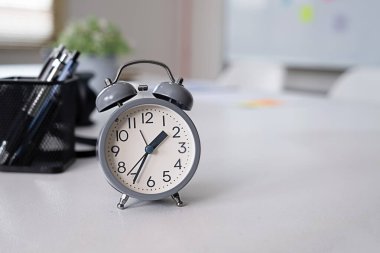 A gray clock on the desk.