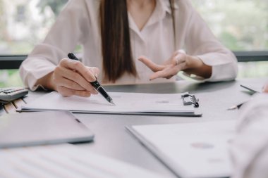 Marketer or analytic manager team dressed in suits working with paper charts and laptops at the meeting room.