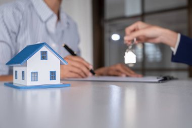 Emlakçı ve müşteri sözleşmesine satın house, sigorta ya da kredi emlak geçmişi tartışmak ile ev modeli.