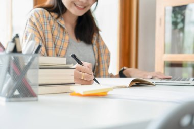 Eğitim konsepti. Öğrenciler kampüs konseptini inceliyor ve beyin fırtınası yapıyorlar. Ders kitapları ve not defterlerine yazma konularını tartışan öğrencilerin kapatılması.