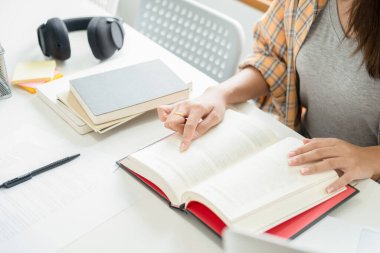 Eğitim konsepti. Öğrenciler kampüs konseptini inceliyor ve beyin fırtınası yapıyorlar. Ders kitapları ve not defterlerine yazma konularını tartışan öğrencilerin kapatılması.