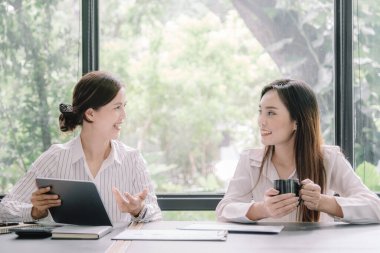 Marketer or analytic manager team dressed in suits working with paper charts and laptops at the meeting room.