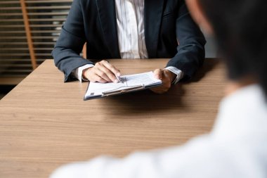 Erkek aday masasında oturuyor ve iş başvurusu için sorulara cevap veriyor ve yeni şirkette mülakat için görüşmeler yapıyor.. 