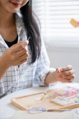 Neşeli ve el yapımı bilezikler yapan genç bir kız.