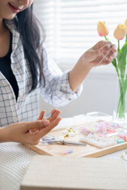 Neşeli ve el yapımı bilezikler yapan genç bir kız.