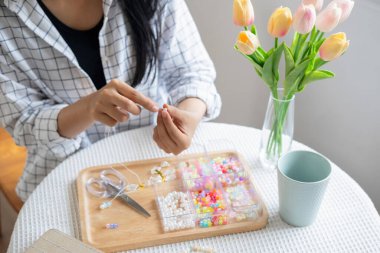 Neşeli ve el yapımı bilezikler yapan genç bir kız.