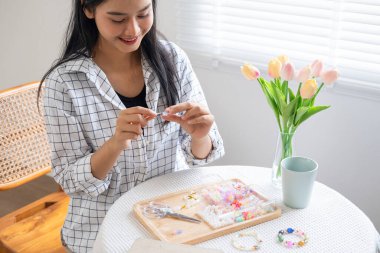 Neşeli ve el yapımı bilezikler yapan genç bir kız.