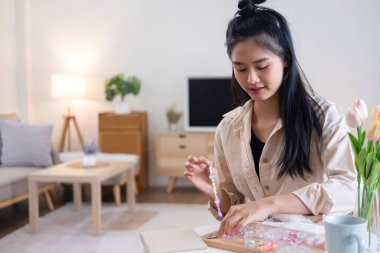 Neşeli ve el yapımı bilezikler yapan genç bir kız.