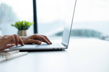 İş kadını iş yerinde ya da evde koltukta oturup dizüstü bilgisayar üzerinde çalışıyor ve şirket için iş planı ve stratejiler oluşturmak için çizelgeler ve grafikler üzerindeki verileri analiz ediyor ve kağıtlara yazıyor. İş konsepti.