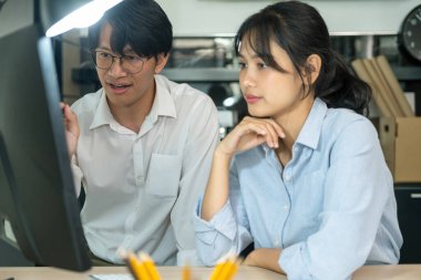 İki erkek ve kadın mühendis, müteahhit veya mimar birlikte çalışarak, inşaat projesinin grafik tasarımı için bilgisayar ekranına bakıyor ve profesyonel ekipmanlarla birlikte çalışma masasında gelişim için tartışıyorlar..