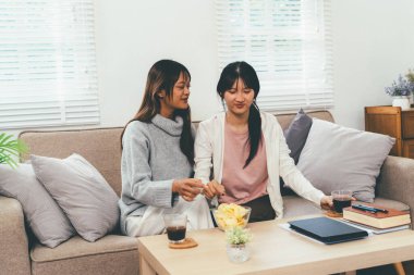 Evde dizüstü bilgisayar kullanan ve kitap okuyan kız öğrenci, İnternet üzerinden öğrenim.