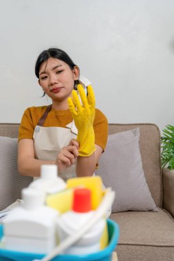 Genç modern Asyalı kadın evde temizlik yapıyor. Kendinden emin.