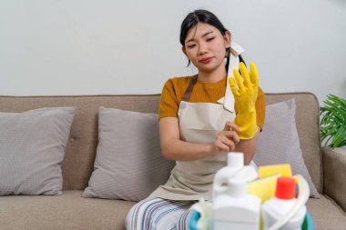 Genç modern Asyalı kadın evde temizlik yapıyor. Kendinden emin.