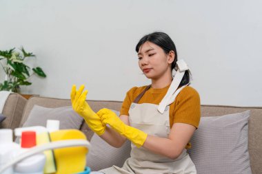 Genç modern Asyalı kadın evde temizlik yapıyor. Kendinden emin.