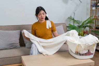 Genç modern Asyalı kadın evde temizlik yapıyor. Kendinden emin.