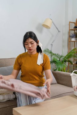 Genç modern Asyalı kadın evde temizlik yapıyor. Kendinden emin.