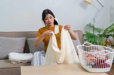 Genç modern Asyalı kadın evde temizlik yapıyor. Kendinden emin.