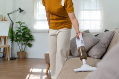 Genç modern Asyalı kadın evde temizlik yapıyor. Kendinden emin.