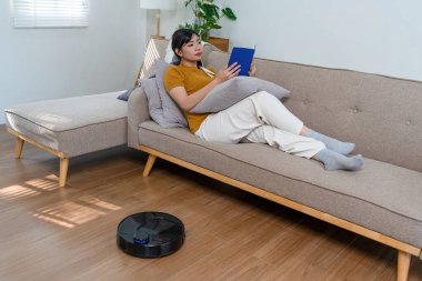 Genç modern Asyalı kadın evde temizlik yapıyor. Kendinden emin.