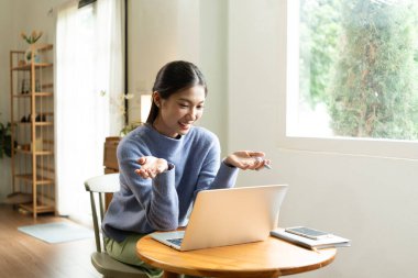 Genç Asyalı kadın pencerenin yanında kitap okuyarak huzurlu bir anın tadını çıkarıyor. Sakin yaşam tarzı, kendi kendine öğrenme ve evdeki farkındalık..