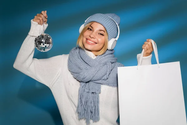 Fröhliche Frau Mit Wintermütze Und Kabellosen Kopfhörern Mit Einkaufstasche Und — Stockfoto