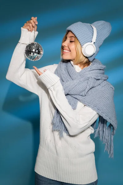 戴着冬帽的快乐女人 带着蓝色迪斯科舞会的无线耳机 — 图库照片