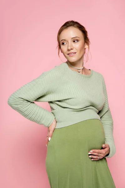 Smiling Pregnant Woman Green Outfit Touching Belly Isolated Pink — Stock Photo, Image