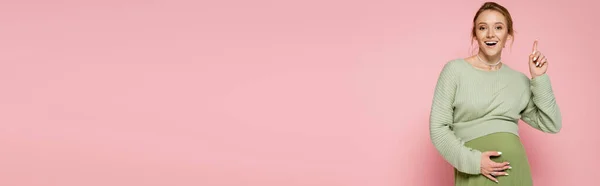 Mulher Grávida Positiva Suéter Apontando Com Dedo Isolado Rosa Banner — Fotografia de Stock