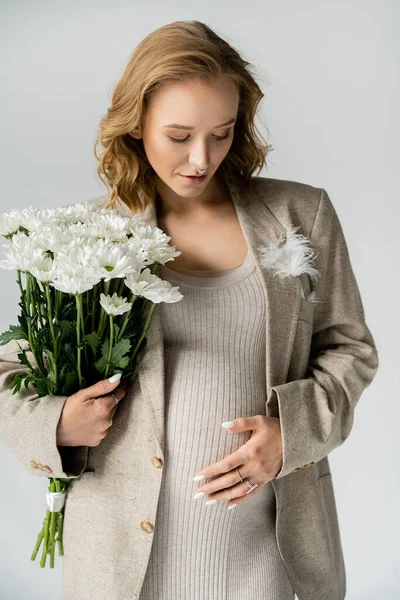 Μοντέρνο Έγκυος Γυναίκα Φόρεμα Και Σακάκι Κρατώντας Λουλούδια Απομονώνονται Γκρι — Φωτογραφία Αρχείου