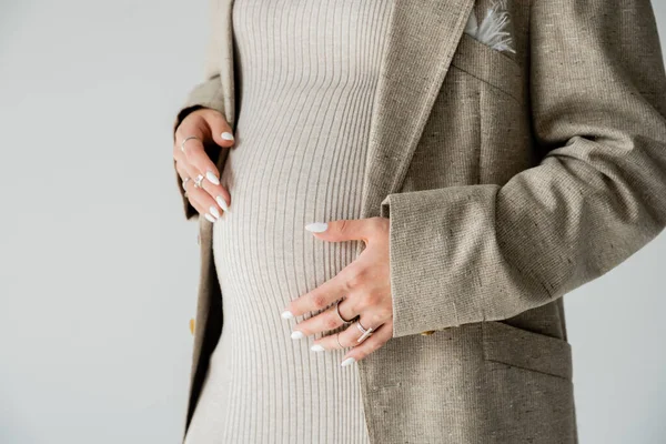 クロップビューのスタイリッシュな妊娠中の女性でジャケットタッチ腹絶縁上のグレー — ストック写真