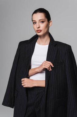 Gri üzerine izole edilmiş ceket giyen şık esmer modelin portresi. 