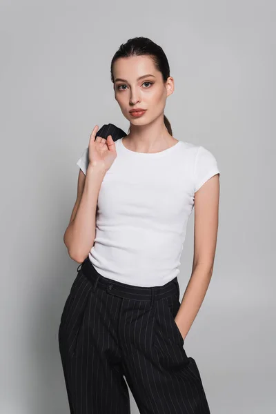 Mujer Joven Moda Camiseta Que Sostiene Chaqueta Sobre Fondo Gris —  Fotos de Stock