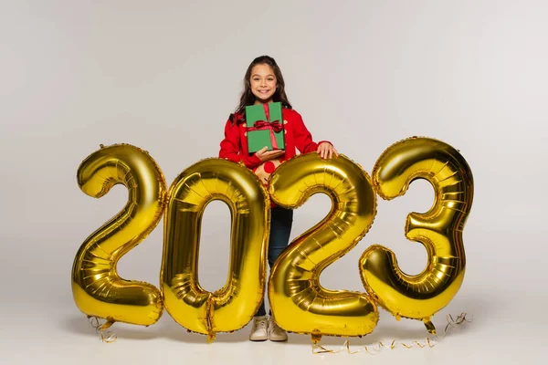 Comprimento Total Criança Feliz Suéter Segurando Natal Presente Perto Balões — Fotografia de Stock