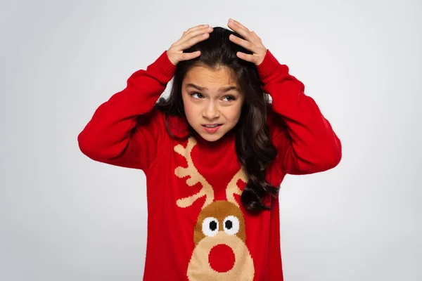 stock image Scared child in red sweater looking away and covering head isolated on grey 