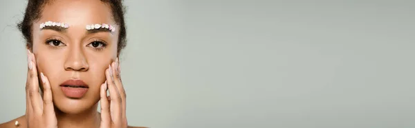Гарна Афроамериканка Квітами Бровах Торкаються Обличчя Ізольовано Сірому Банер — стокове фото