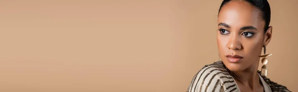 Портрет Элегантной Африканской Американки Золотой Сережке Смотрящей Сторону Изолированной Бежевом — стоковое фото