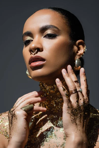 傾向アフリカ系アメリカ人女性の手と体の上に金色の箔と光で灰色に孤立ポーズ — ストック写真