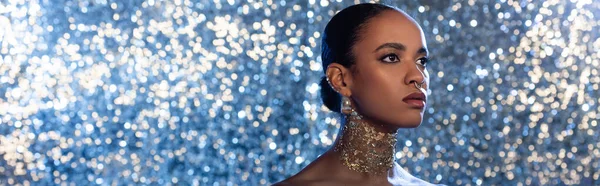 时髦的非洲裔美国女人 脖子上挂着金箔 望着外面闪闪发光的蓝色背景 一面横幅 — 图库照片