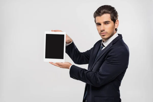 Νεαρός Επιχειρηματίας Κοστούμι Κρατώντας Ψηφιακή Ταμπλέτα Λευκή Οθόνη Απομονωμένη Γκρι — Φωτογραφία Αρχείου